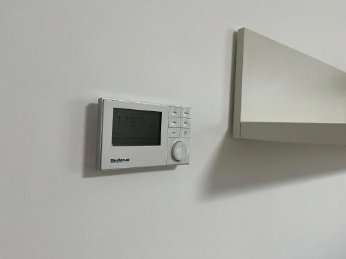 a microwave on a wall with a clock on it at Sweet Home in Barsinghausen