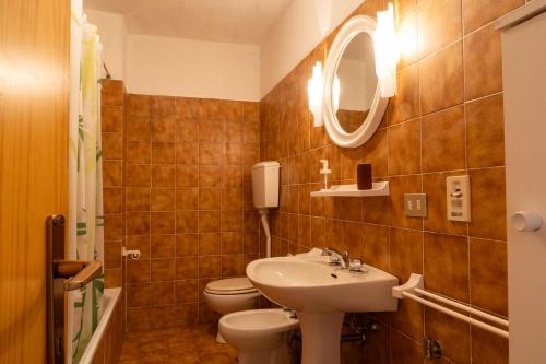 a bathroom with a sink and a toilet and a mirror at Casa il Rio in Riolunato