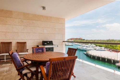 a table and chairs on a balcony with a view of the water at Ph en resort de lujo con acceso a la playa y todas las amenidades in Cancún