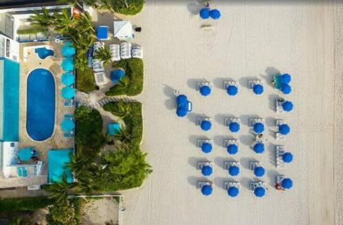 an overhead view of a resort with blue umbrellas at 1BR Apartment with Ocean View in Sunny Isles Beach