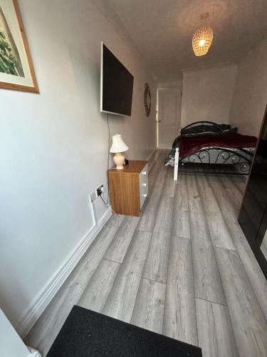 Un dormitorio con una cama y suelo de madera. en Sariyu space studio flat with own bathroom and Kichen, en Rainham