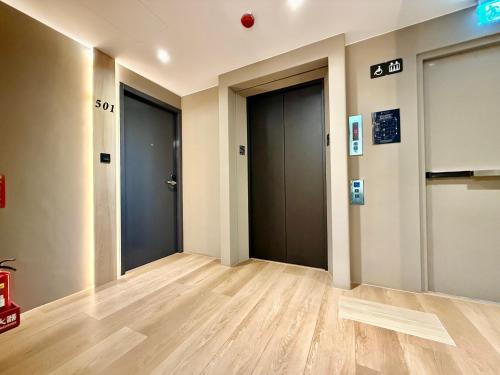 an empty hallway with two elevators in a building at N2 Hotel in Taichung