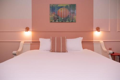 a bedroom with a large white bed with two pillows at The Russell in Nashville