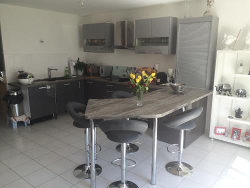 une cuisine avec une table avec un vase de fleurs dessus dans l'établissement Chambre avec vue chez l'habitant, à Saint Pierre en Faucigny