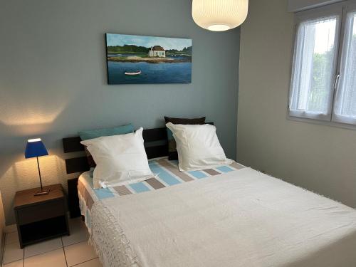 une petite chambre avec un lit et une fenêtre dans l'établissement appartement en front de mer, à Guidel