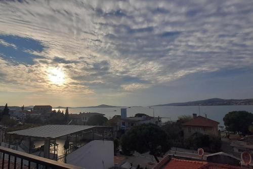 a view of a city with the sun in the sky at aj konukevi müstakil ev dört odalı in Ayvalık