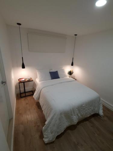 a bedroom with a large white bed with a night stand at Hotel Ventura in Quesada