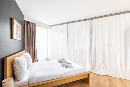 une chambre avec un lit et une grande fenêtre dans l'établissement GuestReady - Black pearl close to the metro, à Paris