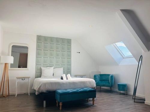 une chambre avec un lit et une chaise bleue dans l'établissement Charmant Studio 6 avec Jacuzzi à Quéven, à Quéven