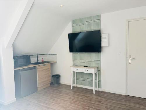 Il comprend une cuisine avec un bureau et une télévision à écran plat. dans l'établissement Charmant Studio 6 avec Jacuzzi à Quéven, à Quéven
