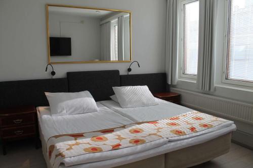 a bedroom with a bed with a mirror on the wall at Best Western Hotel Apollo in Oulu
