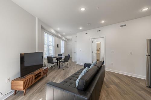 a living room with a couch and a flat screen tv at Huguenot Apt - TH08 - Tourist Homes of Richmond in Richmond