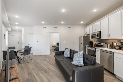a living room with a black couch and a kitchen at Huguenot Apt - TH08 - Tourist Homes of Richmond in Richmond
