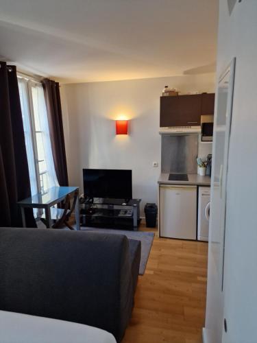 un salon avec un canapé et une cuisine dans l'établissement belle appartement au canal de saint martin, à Paris