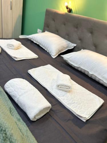 a group of white pillows on a bed at Cibalae Residence, Self Check-In in Vinkovci