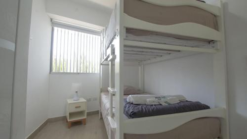 a bedroom with two bunk beds and a window at Condominio Ocean reef in San Bartolo