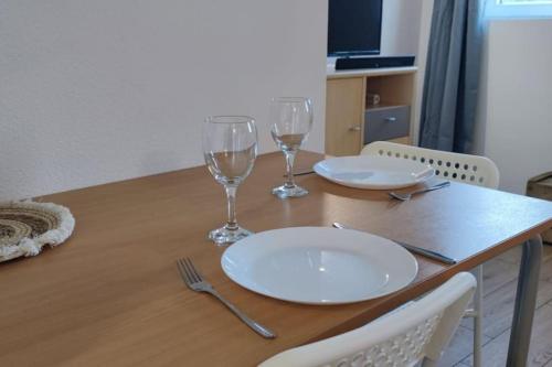 - une table avec deux assiettes et deux verres à vin dans l'établissement Le Diochon, à Sotteville-lès-Rouen