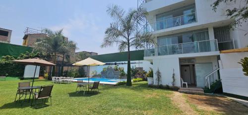 a house with a yard with chairs and a swimming pool at Pacharodeo & Hospedaje in Pachacamac