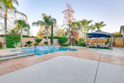 a swimming pool with an umbrella in a yard at Outdoor Oasis and Hot Tub! Spacious Clovis Home in Clovis