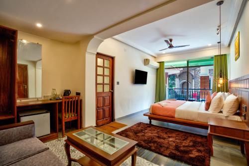 a bedroom with a bed and a living room at Dimaru Boutique Hotel in Calangute