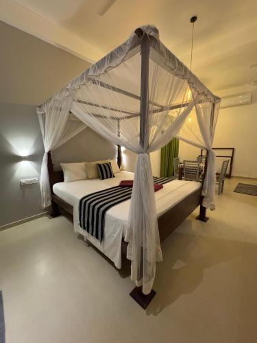a bedroom with a bed with a canopy at Villa Red Lobster in Hikkaduwa