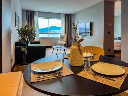 a dining room with a table and a living room at Hotel Bahía de Vigo in Vigo