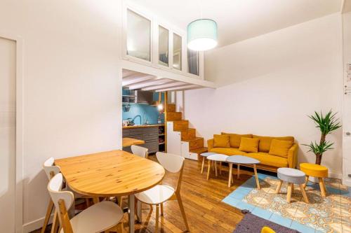 - un salon avec une table en bois et un canapé jaune dans l'établissement Joli - Lovely studio Paris, à Paris