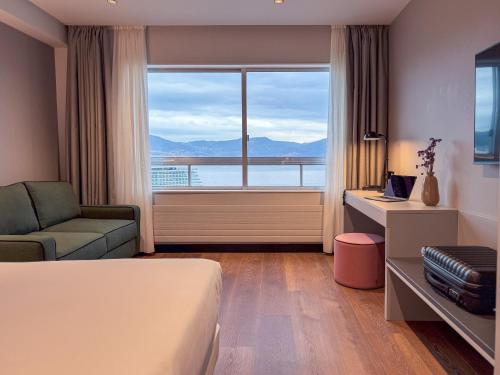 a hotel room with a bed and a large window at Hotel Bahía de Vigo in Vigo