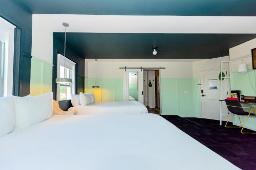 a bedroom with two beds and a desk in it at The Russell in Nashville