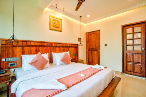 a bedroom with a large bed with a wooden headboard at Dimaru Boutique Hotel in Calangute