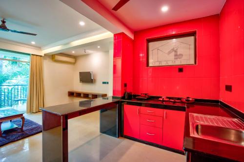 a red kitchen with a black counter top at Dimaru Boutique Hotel in Calangute