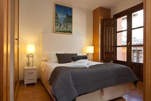 a bedroom with a large bed and a window at Apartamentos Elvira 21 in Granada