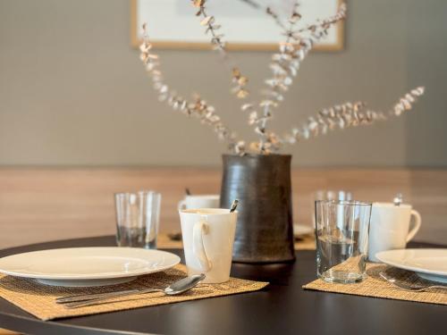 a table with plates and glasses and a vase with flowers at Hotel Bahía de Vigo in Vigo
