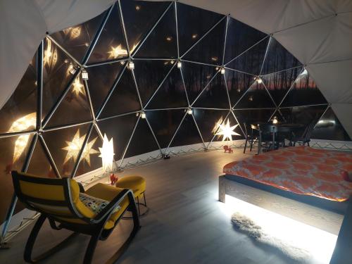 a bedroom in a tent with a bed and a table at Ēdelveisi Lauku sala in Līvbērze