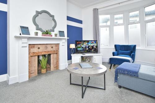 a living room with a couch and a fireplace at Bentley House - By Sigma Stays in Crewe