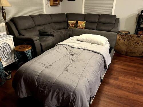 a living room with a bed and a couch at Peaceful Pine Place Cabin in Pine