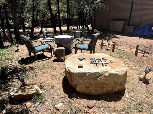 a group of chairs sitting around a large rock at Peaceful Pine Place Cabin in Pine