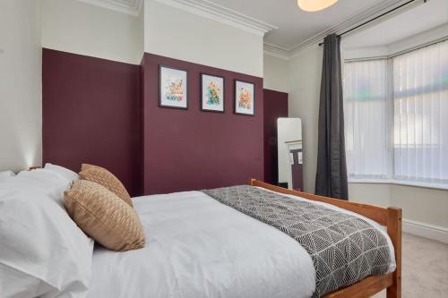 a bedroom with a white bed and a purple wall at Cosy 3-Bedroom House With Street Parking in Stockton-on-Tees