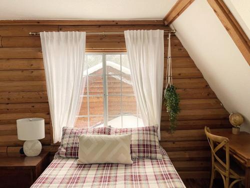 a bedroom with a bed and a window at Log Cabin w/ pool, spa, game room, sleeps 20 in Coarsegold