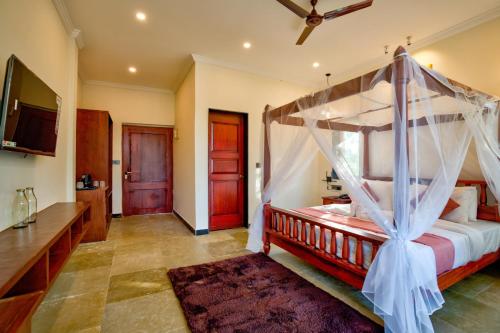 a bedroom with a bed with a canopy at Dimaru Boutique Hotel in Calangute