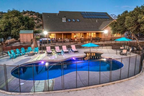 コアーシーゴールドにあるMountain Elegance w/ pool, spa, projectorの家の前のプール(椅子、パラソル付)