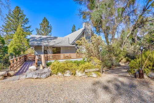 a house with a porch and a wooden fence at Stimboli Lodge- Sleeps 16 with tons of games and fun in Oakhurst