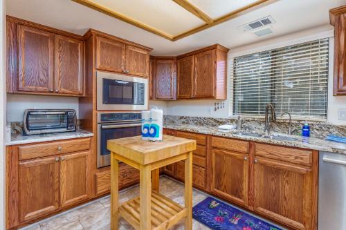 a kitchen with wooden cabinets and a small table in it at Stimboli Lodge- Sleeps 16 with tons of games and fun in Oakhurst