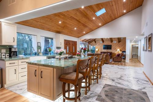 a kitchen with a large island with bar stools at Sunset Retreat- TWO houses with hot tub, firepit, multiple kitchens, sleeps 20 in Coarsegold