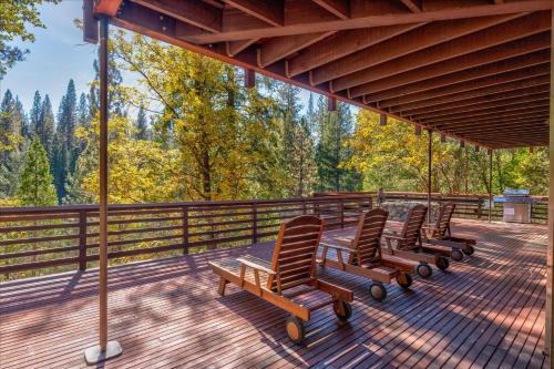 Una fila de sillas en una terraza con árboles. en River's Edge w/ BBQ, Wifi, Firepit!, en North Wawona