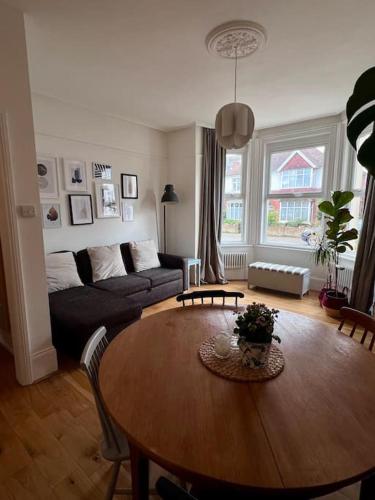 a living room with a table and a couch at Seashell Apartment - Central location in Folkestone