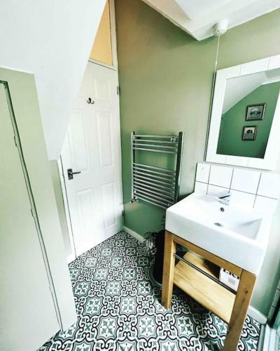 a bathroom with a sink and a mirror at Seashell Apartment - Central location in Folkestone