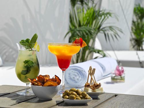 a table with two cocktails and a bowl of nuts at The One Palácio da Anunciada in Lisbon