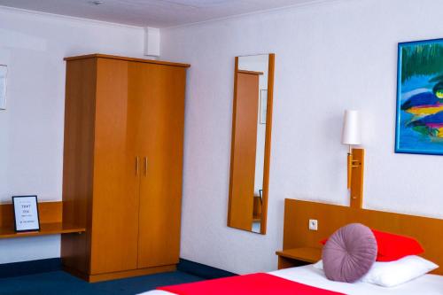 a bedroom with a bed and a wooden cabinet at Hotel Professor Leuven Centrum in Leuven