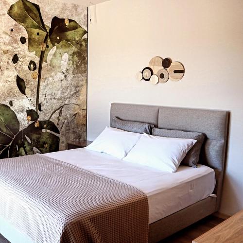 a bedroom with a bed with a plant on the wall at Villa Onari in Alexandroupoli